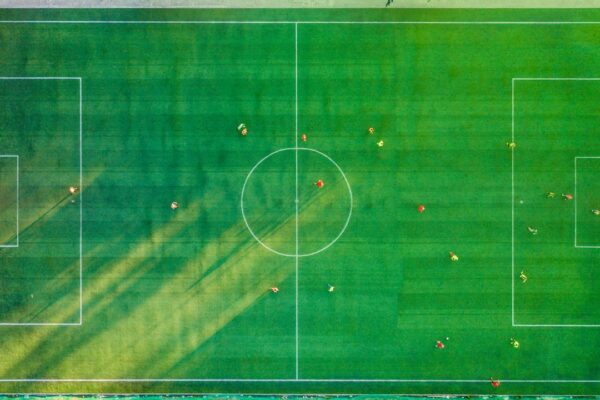 Voetbal met krijtlijnen op een grasveld, symbool voor voetbaltermen en spelregels