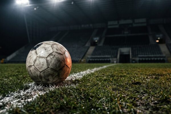 Een voetbal op de kalklijn van een verlicht veld bij avond, sfeerbeeld bij de transfers van FC Utrecht