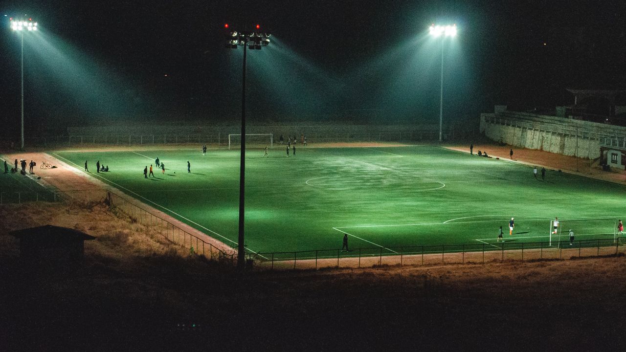 Het Feyenoord programma: verlicht voetbalveld bij avond