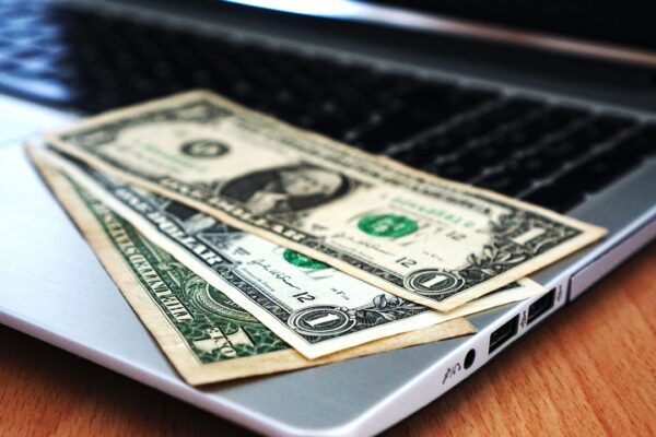 Dollarbiljetten op een laptop, symbool voor een voetballer die ondernemer werd