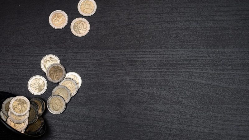 Euromunten op een donkere houten ondergrond, symbool voor het fortuin van een topspits