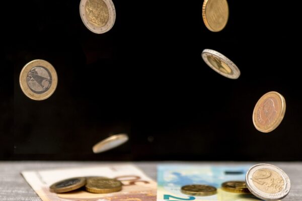 Euromunten en bankbiljetten die op een donkere tafel vallen, symbool voor een goedbetaalde maar door blessures getekende loopbaan