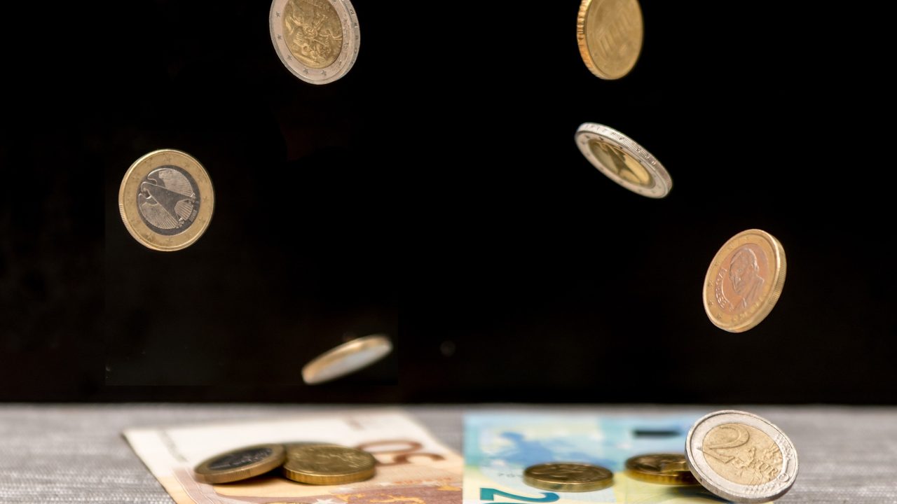 Euromunten en bankbiljetten die op een donkere tafel vallen, symbool voor een goedbetaalde maar door blessures getekende loopbaan