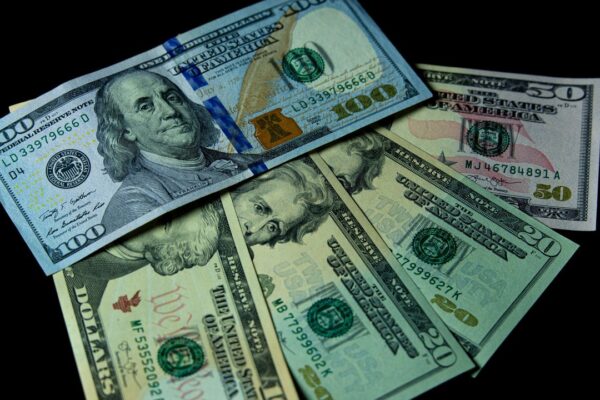 Amerikaanse dollarbiljetten op een zwarte achtergrond, symbool voor de internationale verdiensten van een voetballer