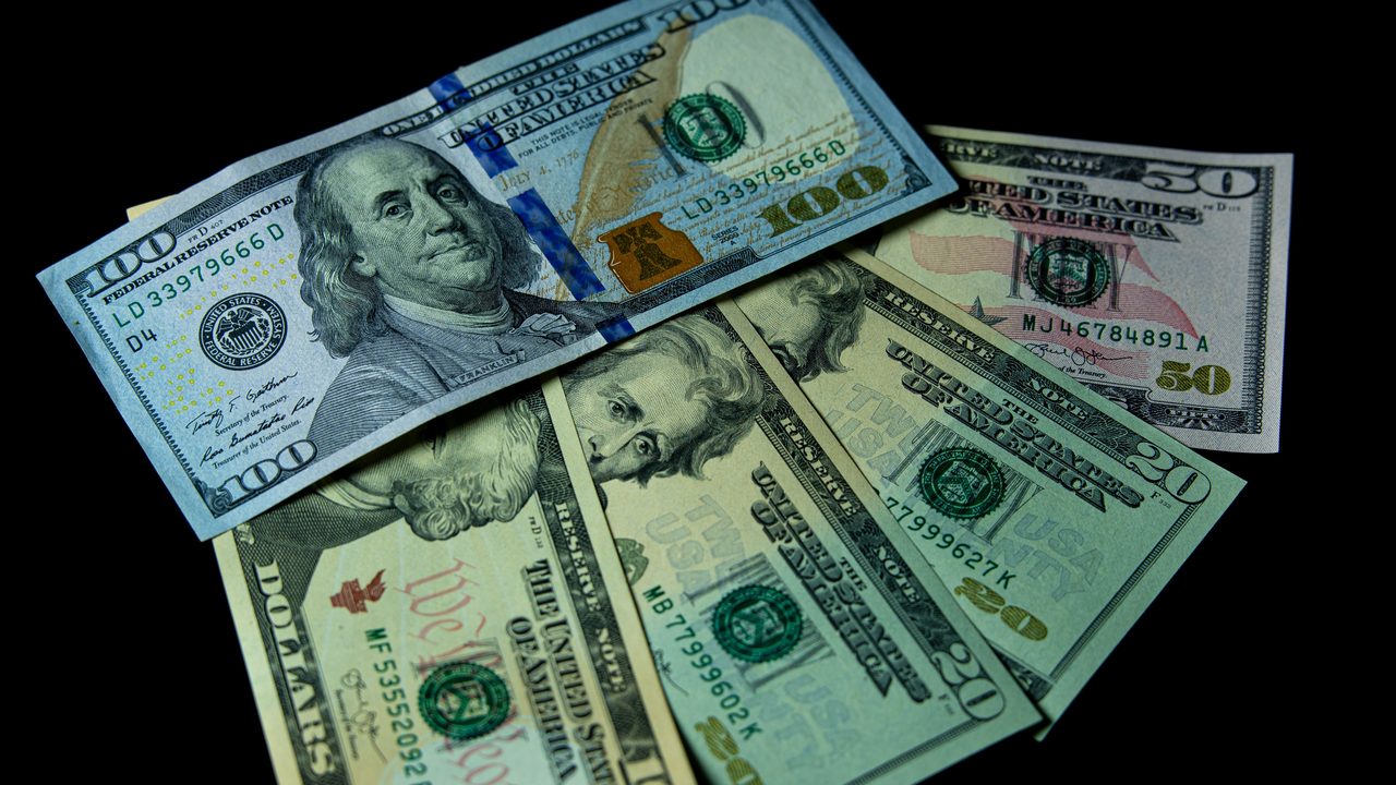 Amerikaanse dollarbiljetten op een zwarte achtergrond, symbool voor de internationale verdiensten van een voetballer