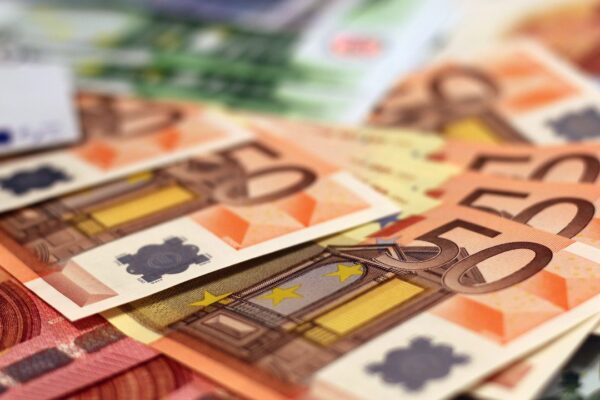 Stapel euro-bankbiljetten op een donkere achtergrond, symbool voor het vermogen en de verdiensten van een profvoetballer
