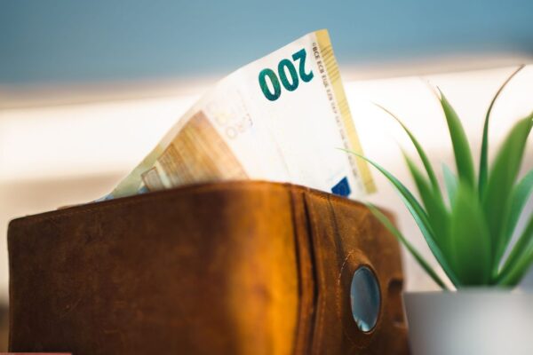 Leren portemonnee met eurobiljetten op een donkere achtergrond, symbool voor de verdiensten van een internationale topcarrière