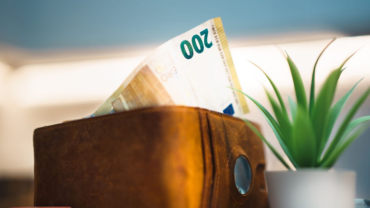 Leren portemonnee met eurobiljetten op een donkere achtergrond, symbool voor de verdiensten van een internationale topcarrière