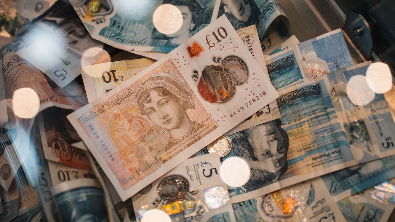 Britse pond-bankbiljetten en munten op een donkere achtergrond, symbool voor de verdiensten van een keeper in Engeland
